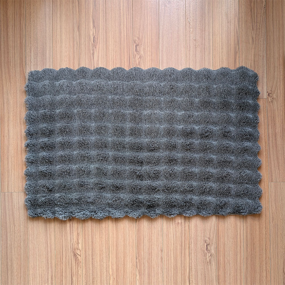 Gray textured doormat on a wooden floor