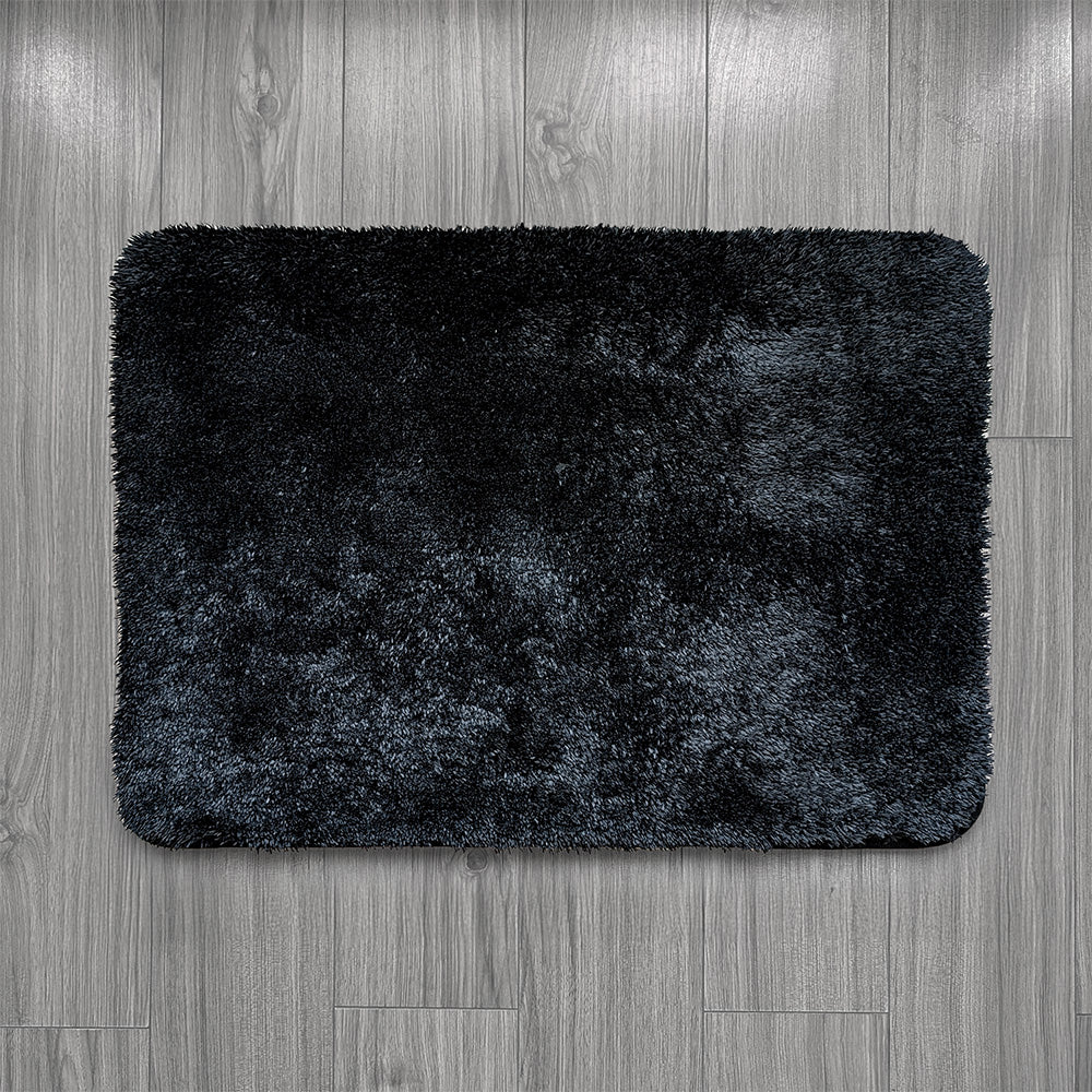 Black bath mat on a wooden floor
