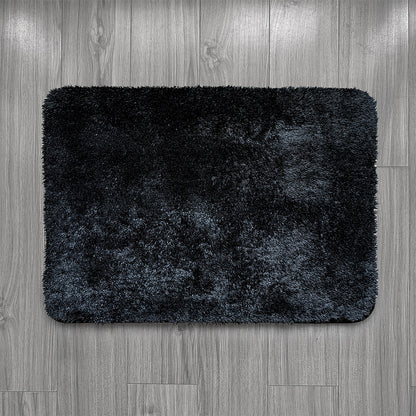 Black bath mat on a wooden floor