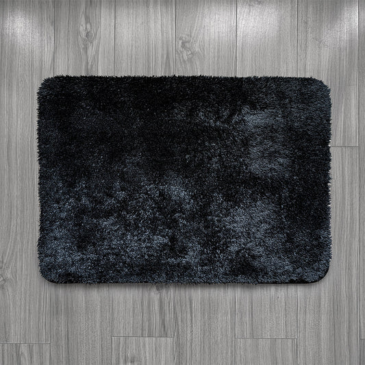 Black bath mat on a wooden floor