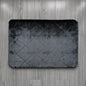 Gray textured bath mat on a wooden floor