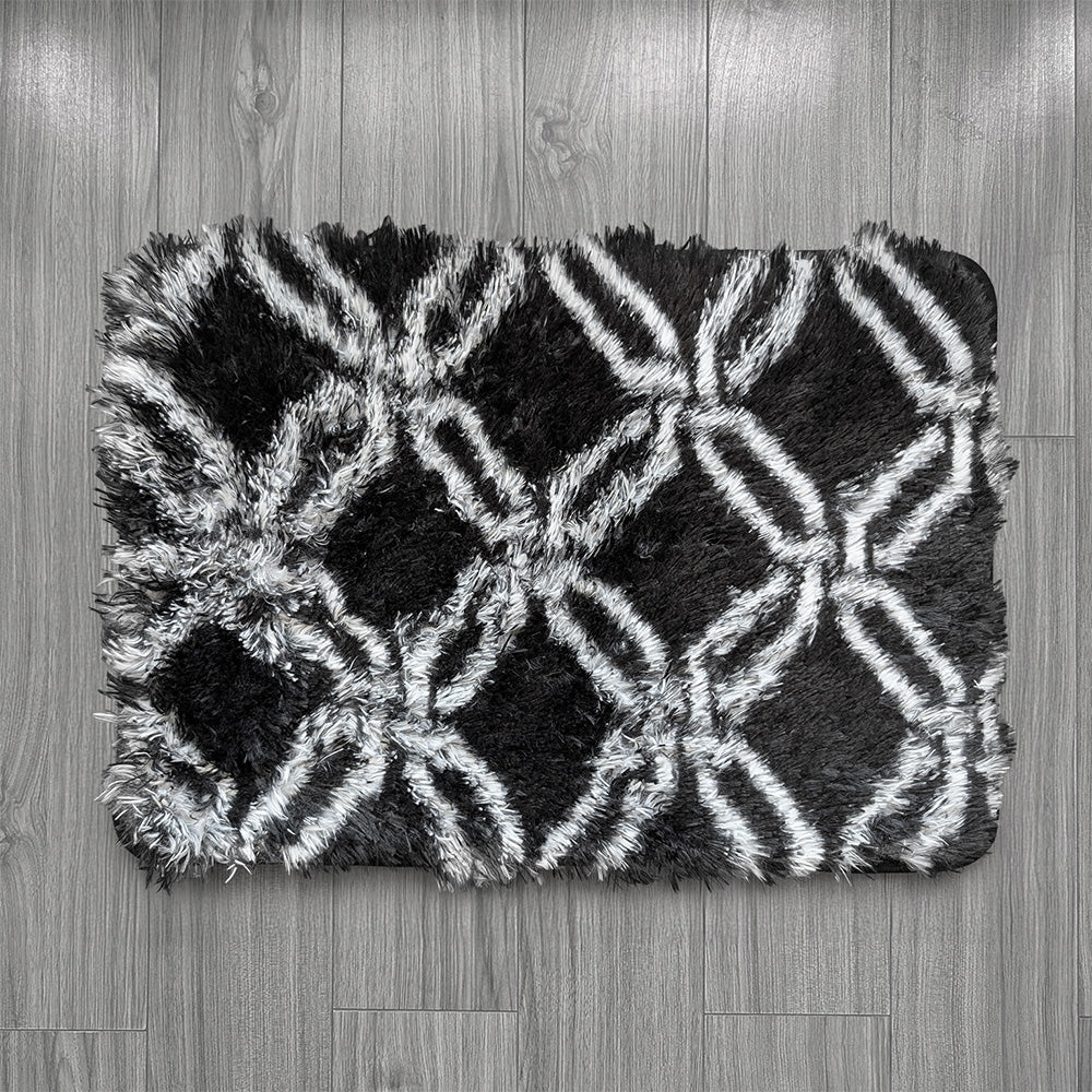 Black and white patterned rug on a wooden floor