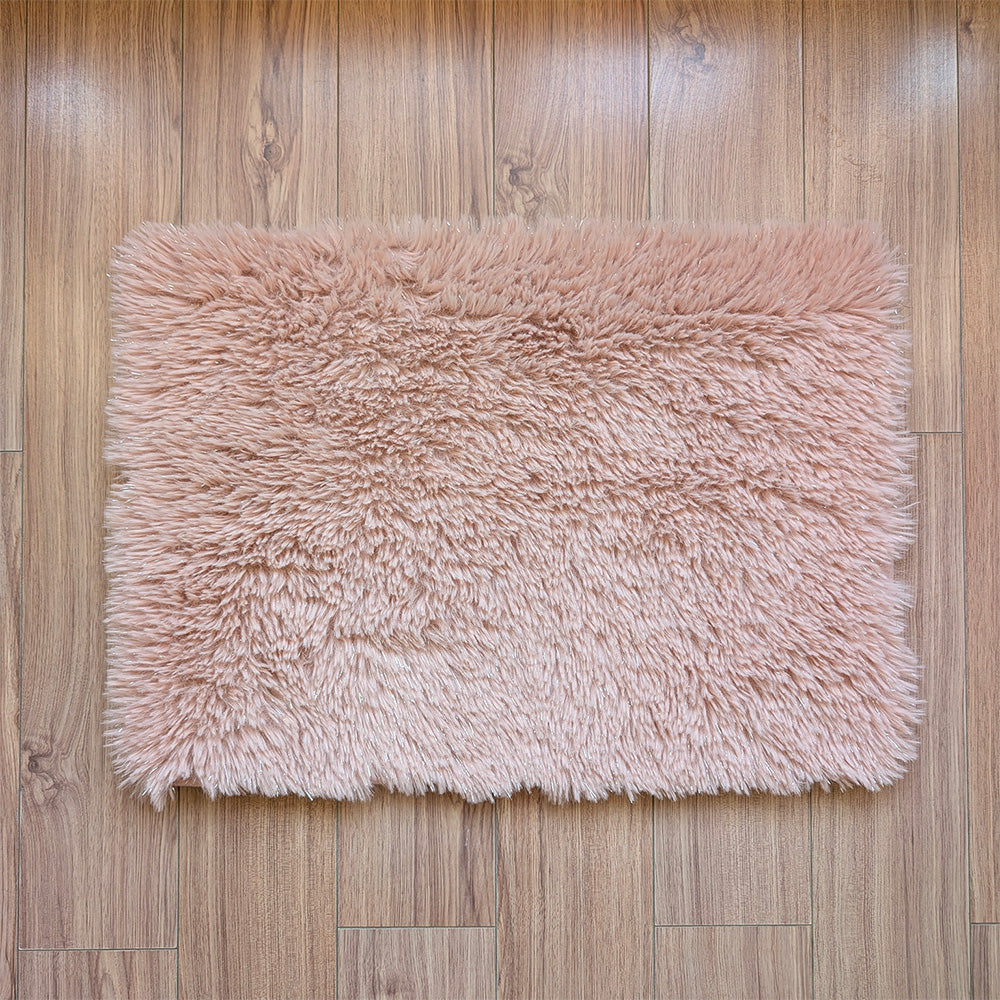 Pink fluffy rug on a wooden floor