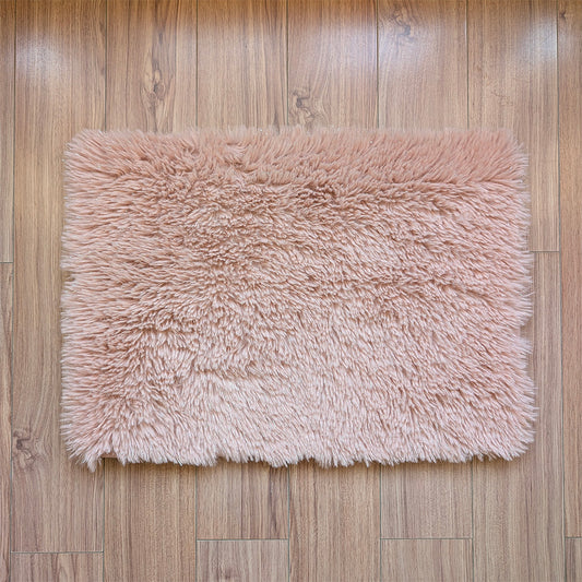 Pink fluffy rug on a wooden floor