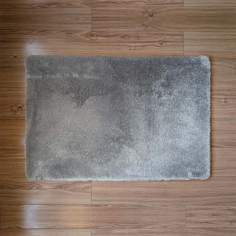 Gray bath mat on a wooden floor