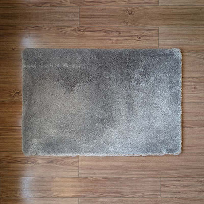 Gray bath mat on a wooden floor