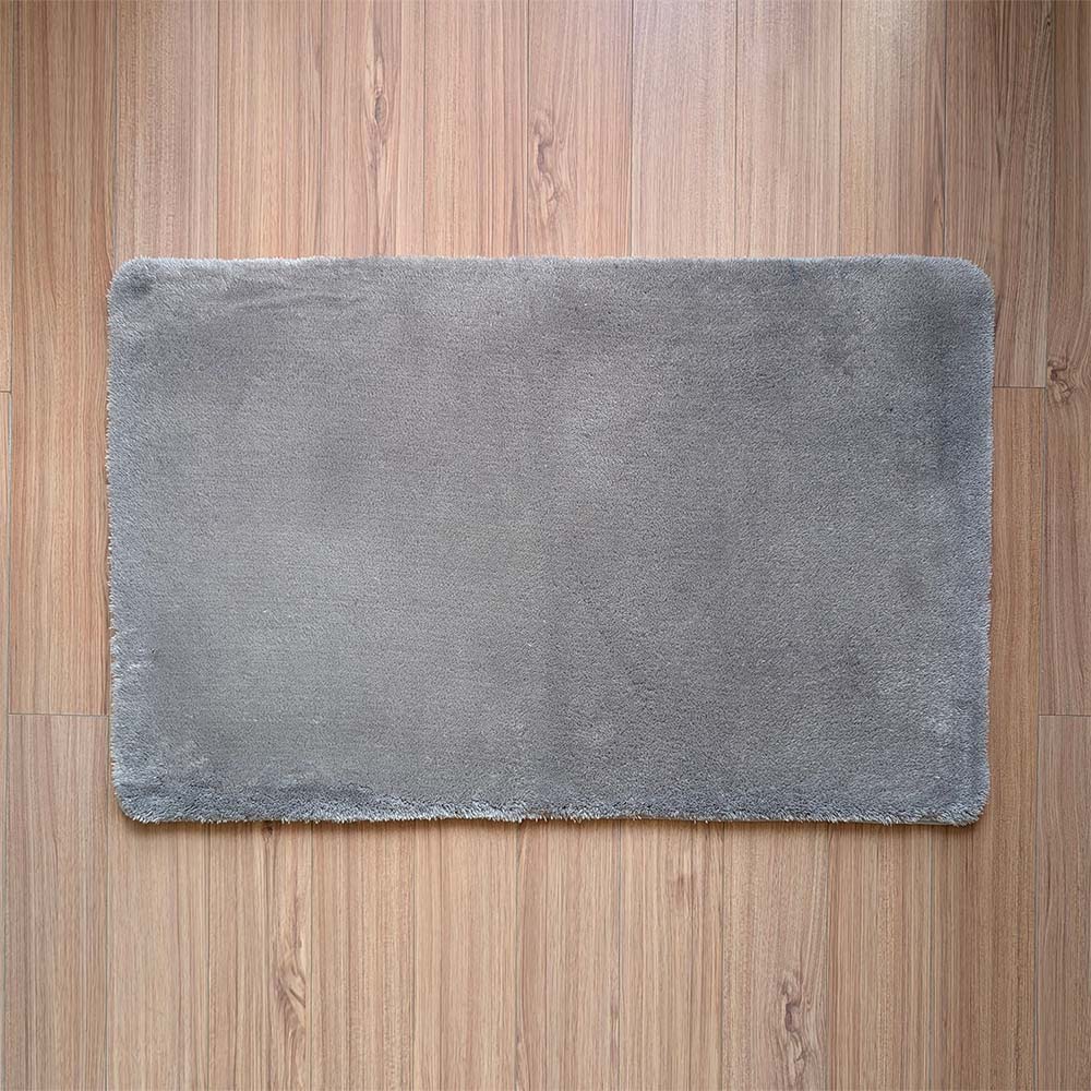 Gray bath mat on a wooden floor