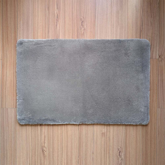 Gray bath mat on a wooden floor