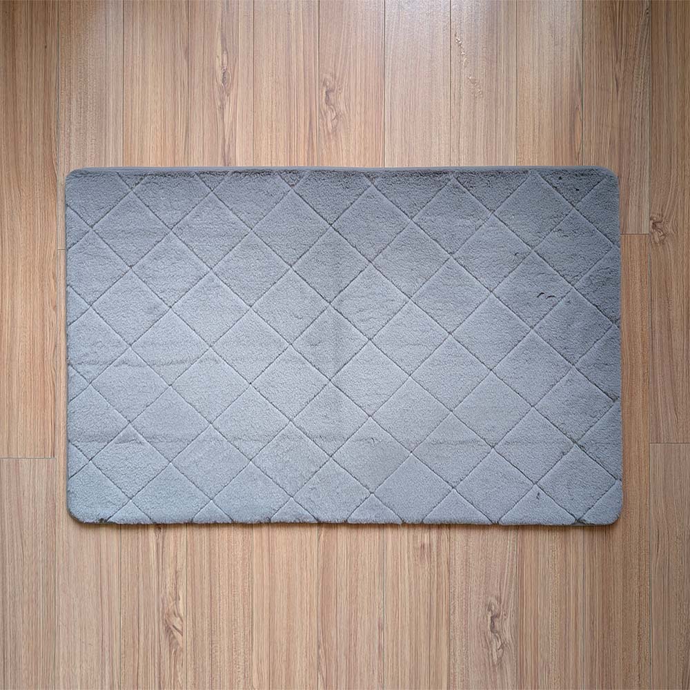Gray quilted mat on a wooden floor