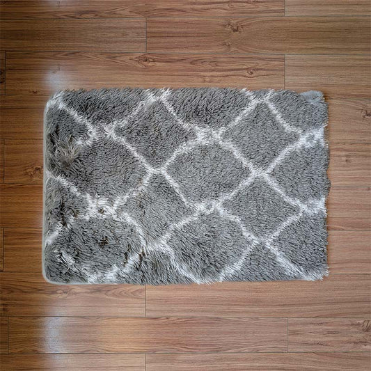 Gray textured rug with white geometric pattern on a wooden floor