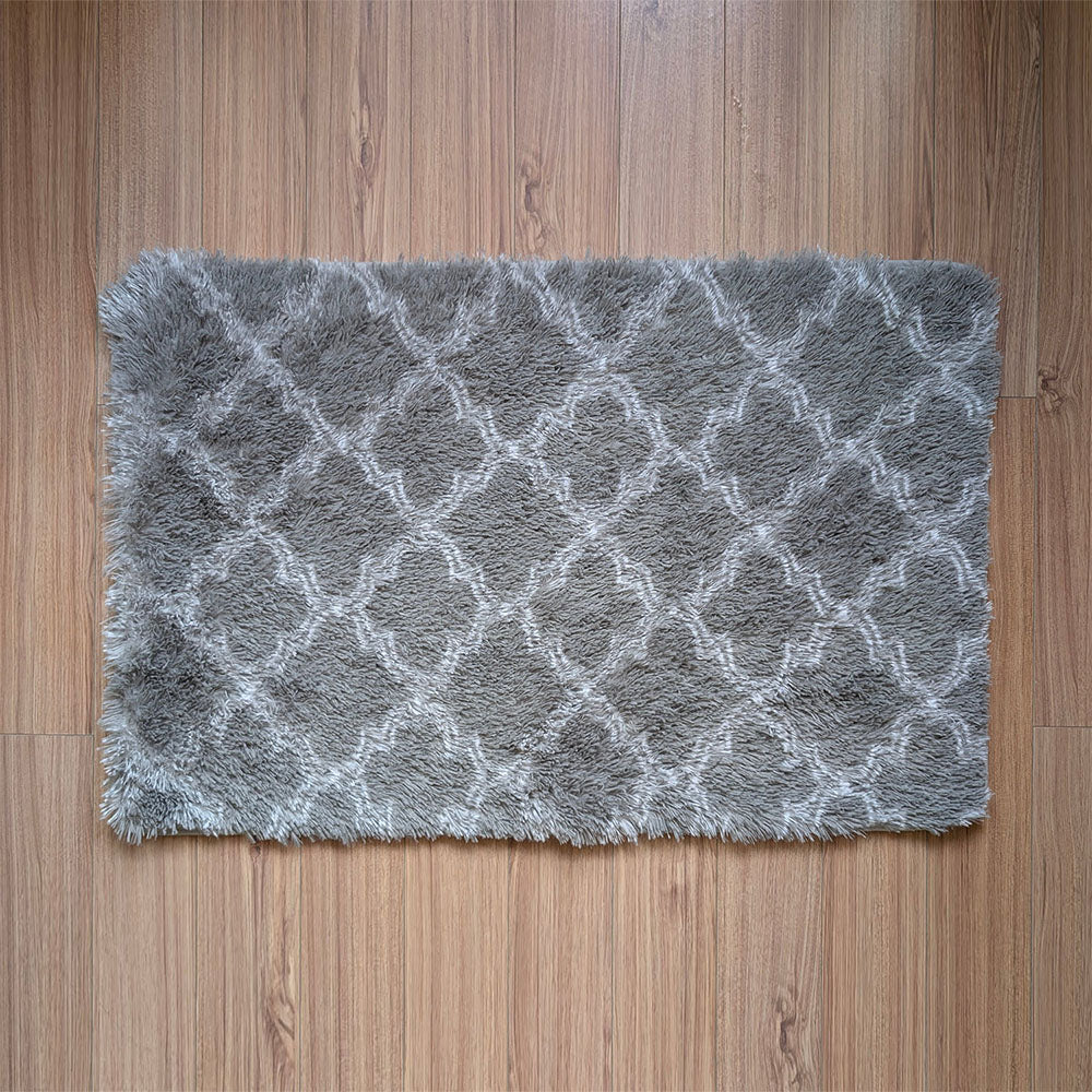 Gray textured rug with a diamond pattern on a wooden floor