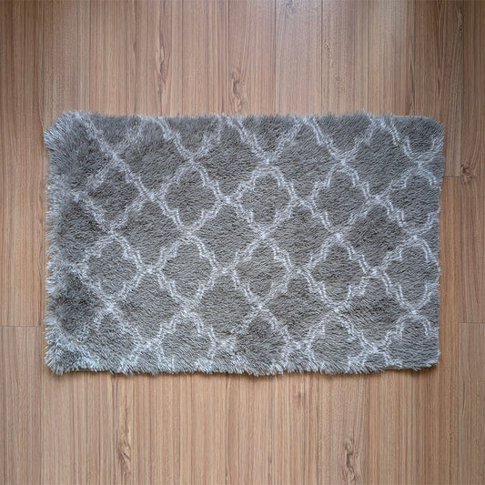 Gray textured rug with a diamond pattern on a wooden floor