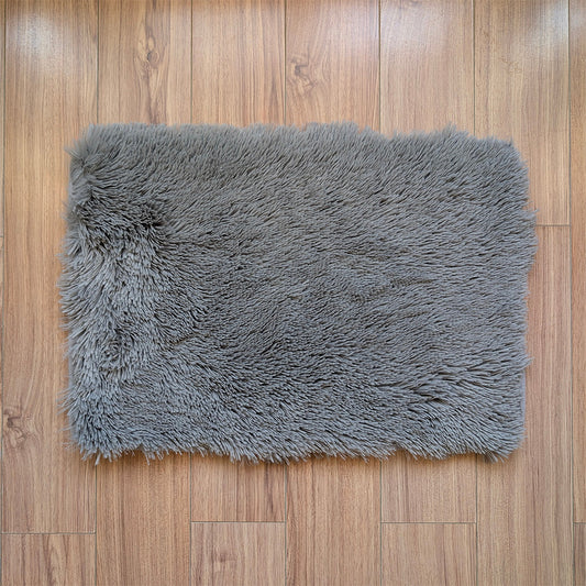 Gray shaggy rug on a wooden floor