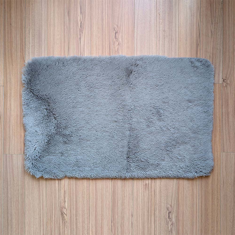 Gray fluffy rug on a wooden floor