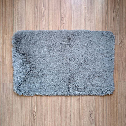 Gray fluffy rug on a wooden floor