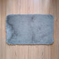 Gray fluffy rug on a wooden floor