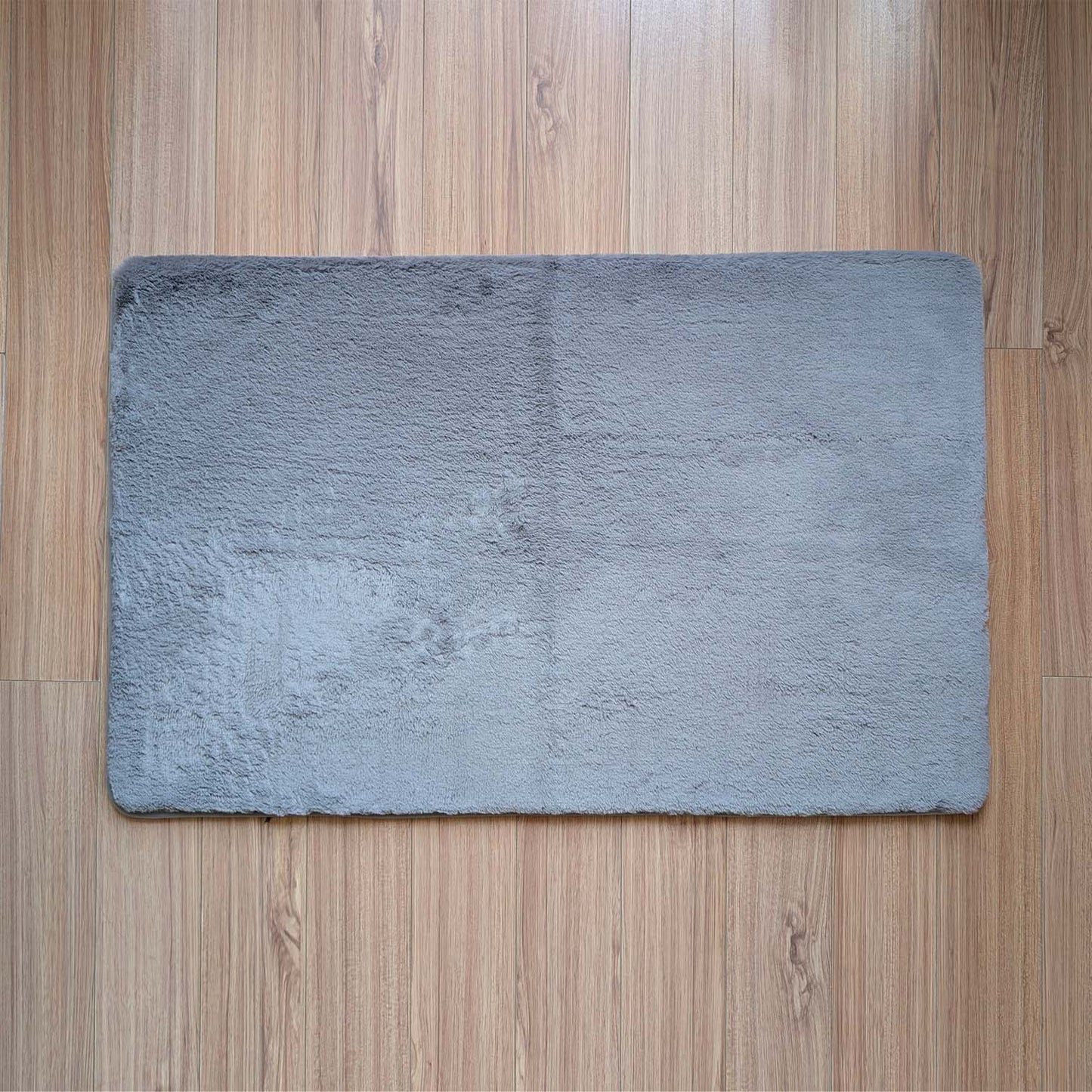 Gray bath mat on a wooden floor