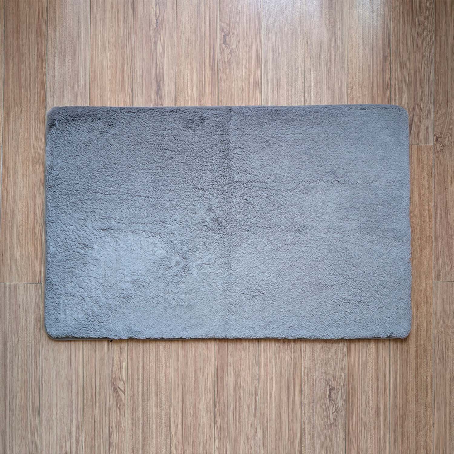 Gray bath mat on a wooden floor
