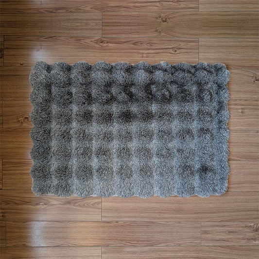 Gray fluffy rug on a wooden floor