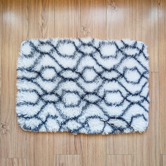 Fluffy white and gray patterned rug on a wooden floor