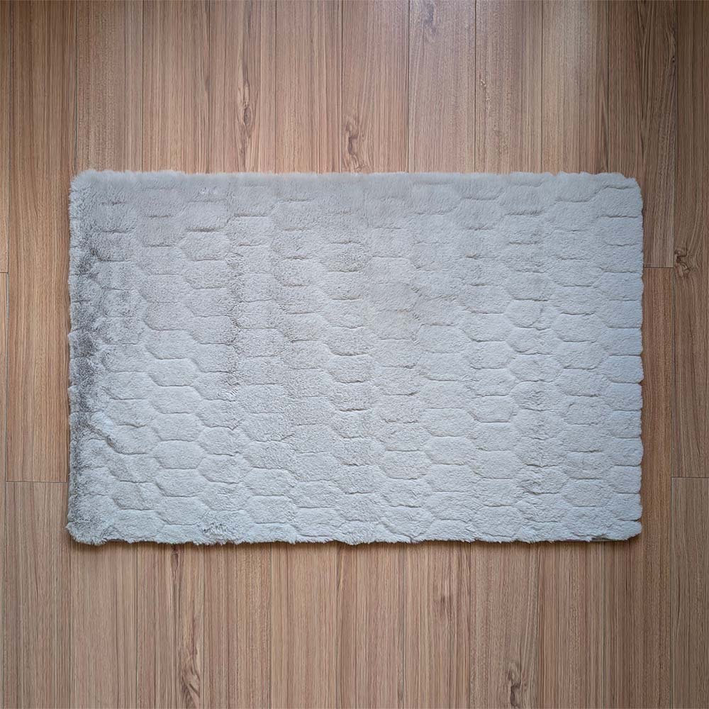 Gray textured bath mat on a wooden floor
