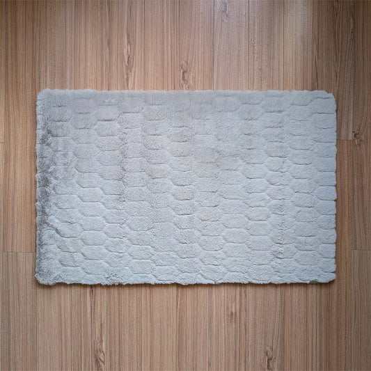 Gray textured bath mat on a wooden floor