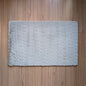 Gray textured bath mat on a wooden floor