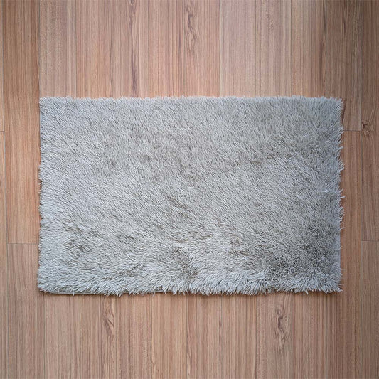 Gray shaggy rug on a wooden floor