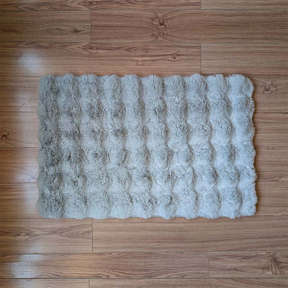 Fluffy gray rug on a wooden floor