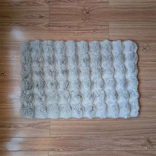 Fluffy gray rug on a wooden floor