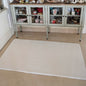 White quilted mat on a marble floor in front of a glass-fronted cabinet.
